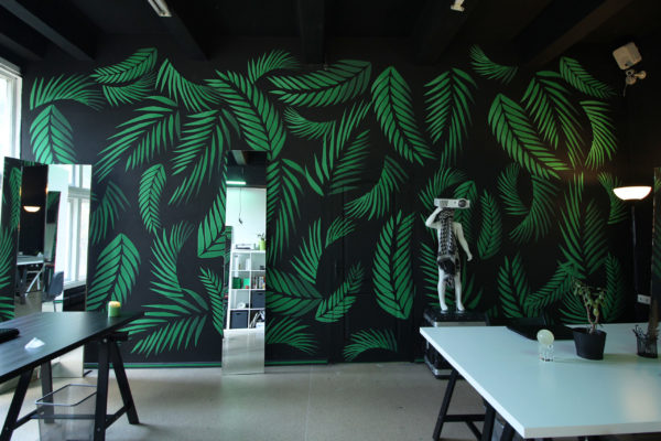 Photo studio office rest zone interrior with black wall with green palm leaves